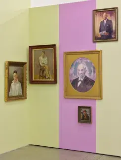 Five painted portraits with washed out tones begin to pop against the pale yellow and light fuchsia wall panels. As the blocks of colour are reflected faintly in each portrait’s colouration, a tonal theme begins to thread the disparate images together. 