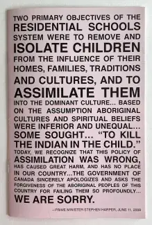 A light pink paper pamphlet is filled to the edges with bold black sans serif text in all-caps which reads in part: Two primary objectives of the residential schools system were to remove and isolate children from the influence of their homes, families, traditions and cultures, and to assimilate them into the dominant culture…based on the assumption Aboriginal cultures and spiritual beliefs were inferior and unequal…some sought…quote, to kill the Indian in the child, unquote…