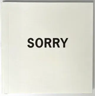 Off-white cardstock covers a small square book. The word SORRY is written in all-caps in bold sans serif font in the centre. 