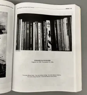 : A large book is opened to a black and white image of a row of books on a shelf. Below the words: Edward David Busby, August 14, 1928 - November 21, 1994. You were always busy. You were always caring. You were always sensitive. You were always hopeful. You loved and you were loved.